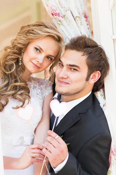Jag älskar dig. Bröllop par håller ett kort i form av hjärta. De är stående och leende. — Stockfoto
