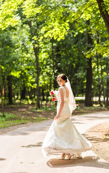 Bela noiva com buquê de casamento no jardim — Fotografia de Stock