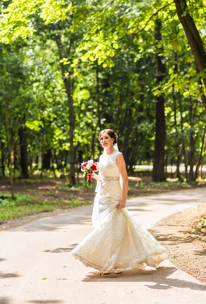 Красивая невеста со свадебным букетом в саду — стоковое фото