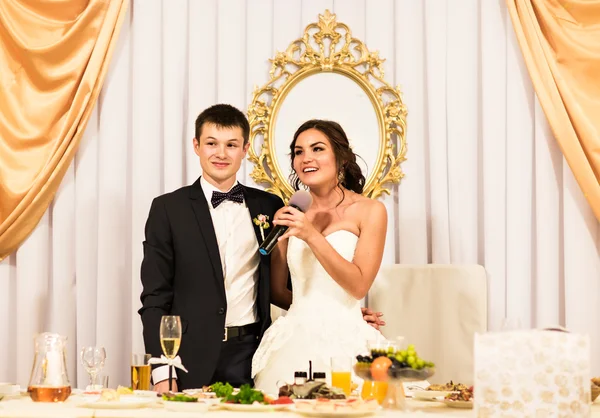 Noiva e noivo comemorando com os convidados na recepção — Fotografia de Stock
