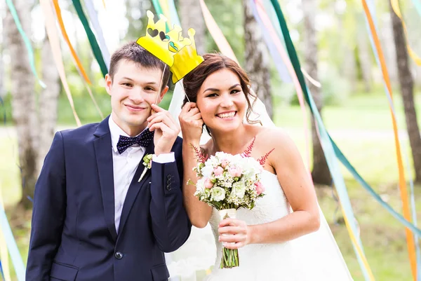 Aprilscherz. Hochzeitspaar posiert mit Krone, Maske. — Stockfoto