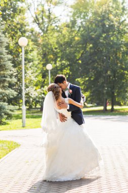 onu kucaklayan Düğün çifti, sarılma bir buket çiçek, holding gelin damat