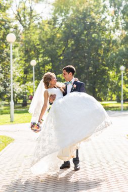 onu kucaklayan Düğün çifti, sarılma bir buket çiçek, holding gelin damat