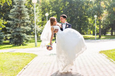 onu kucaklayan Düğün çifti, sarılma bir buket çiçek, holding gelin damat