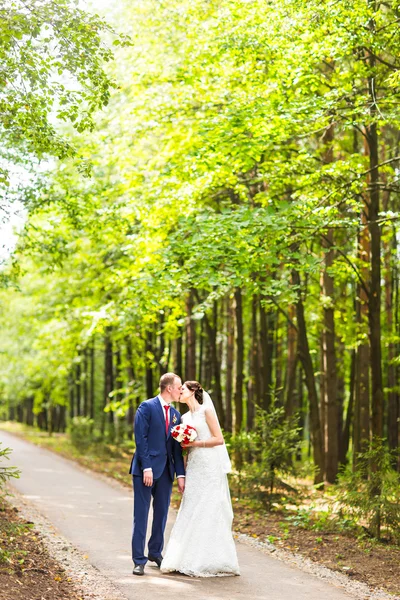 Pareja de bodas divirtiéndose y caminando por el parque —  Fotos de Stock