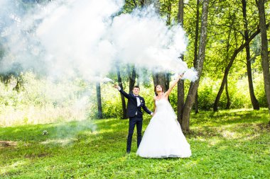 Evlilik, aşk, ilişki, evlilik. Gelin ve damat mavi duman ile gülümseyen