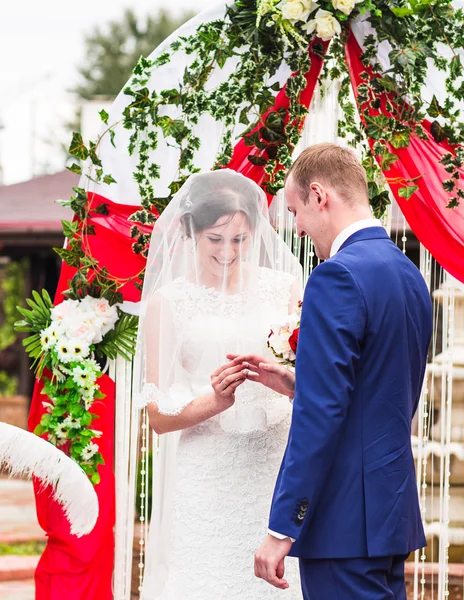 결혼식 복장에 부부 교환 배경에 아치와 반지 — 스톡 사진
