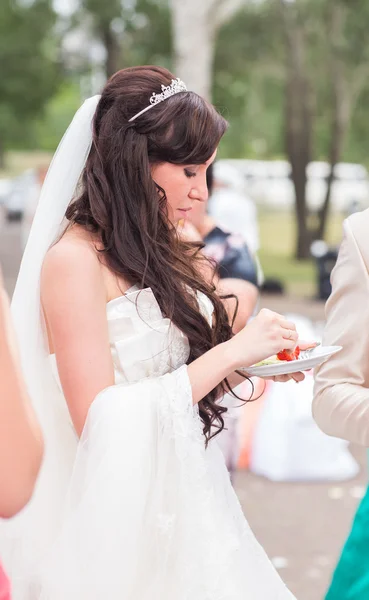 Приваблива біла наречена їсть полуницю на відкритому повітрі — стокове фото