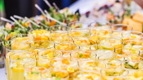 Beautiful line of different coloured cocktails on a open air party,  catering table