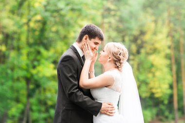 Öpüşme ve açık havada kucaklayan güzel romantik Düğün çifti