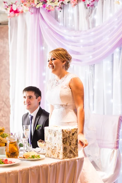 Noiva e noivo desfrutando refeição na recepção do casamento — Fotografia de Stock