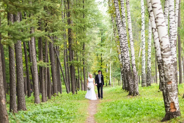 Наречений і наречений тримає руки на відкритому повітрі — стокове фото