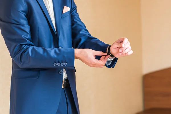 De bruidegom zet op een horloge — Stockfoto