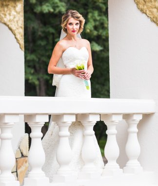 Genç gelin buketi, açık havada tutan gelinlik