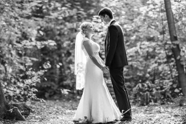 iki sonra düğün kıyafetleri ile bir buket çiçek, gelin ve damat açık havada