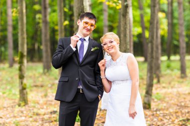 Nisan bir gün. Evlilik çift sopa dudakları ile poz maske.