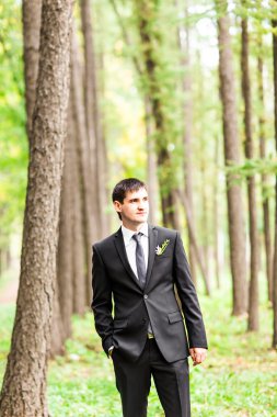 Yakışıklı damat niteliğine takım elbiseli. Erkek portre açık havada. Adam poz.