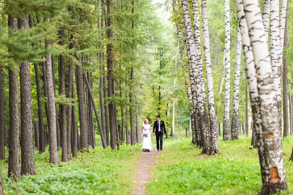 Coppia in abito da sposa con un mazzo di fiori, sposa e sposo all'aperto — Foto Stock