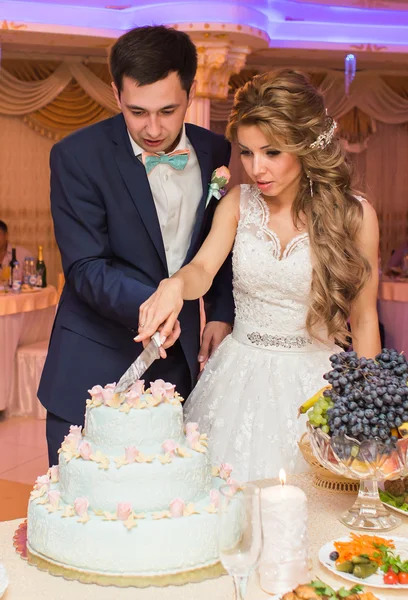 De ceremonie van het huwelijk. Bruid en bruidegom snijden taart. — Stockfoto