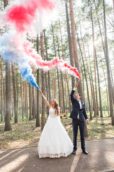 Wedding couple with color smoke in the summer park. Colour bomb — Stock Photo, Image