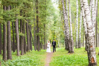 Gelin ve damat dışarıda el ele tutuşuyorlar.