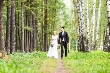 Gelin ve damat dışarıda el ele tutuşuyorlar.