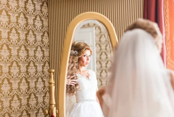 Jovem noiva olha para si mesma no espelho — Fotografia de Stock