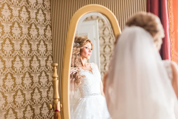 Jovem noiva olha para si mesma no espelho — Fotografia de Stock