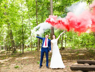 Gelin ve damat ile sis bombası ağaçlar arka plan üzerinde