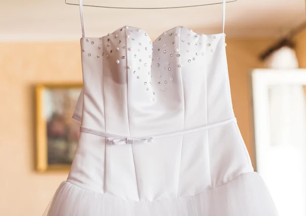 El vestido de novia perfecto en una percha en la habitación de la novia — Foto de Stock