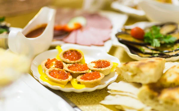 Caviar vermelho em tartarugas na placa branca — Fotografia de Stock