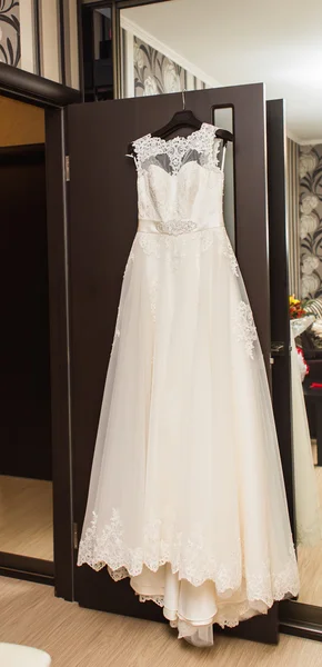 El vestido de novia perfecto en una percha en la habitación de la novia — Foto de Stock