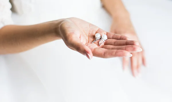 Pendientes de perlas en las manos —  Fotos de Stock