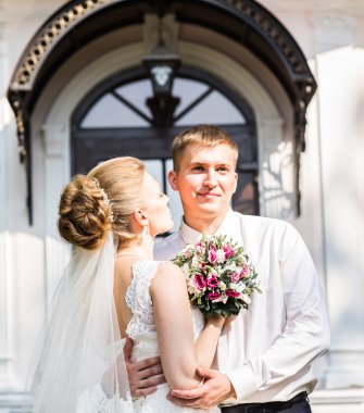 sarılma, elinde bir buket çiçek, onu kucaklayan damat gelin düğün çifti