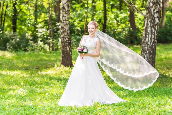 Schöne Braut mit Blumenstrauß im Freien — Stockfoto