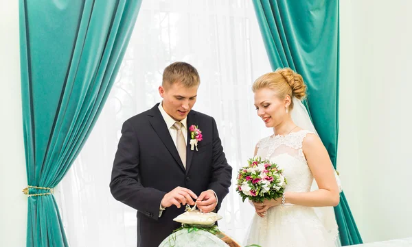 Groom slipping ring on finger of bride at wedding — Stock Photo, Image