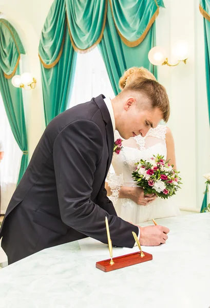 結婚許可証または結婚式の契約署名する新郎新婦 — ストック写真
