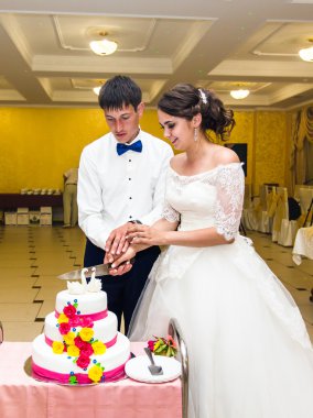 Gelin ve damat düğün pastalarını kesiyorlar.