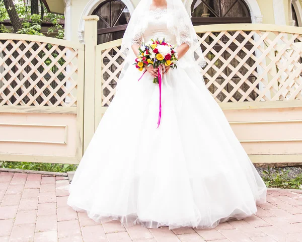 Mooie bruid met bruiloft boeket bloemen buiten in park. — Stockfoto