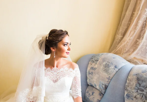 Brunette noiva sentada na poltrona no quarto — Fotografia de Stock