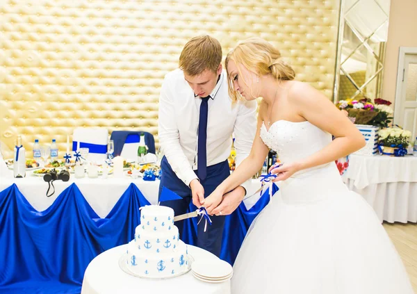 Novia y el novio está cortando su pastel de bodas — Foto de Stock