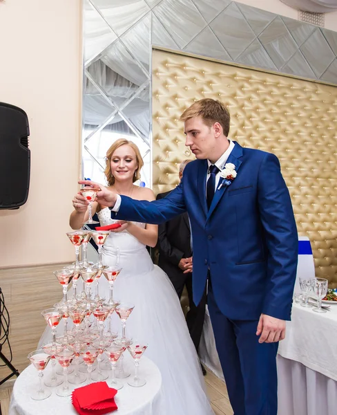 Hermosa pareja de boda está vertiendo champán en el interior. Belleza del interior nupcial para el matrimonio . — Foto de Stock