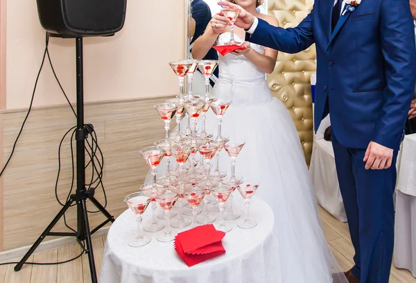 Beautiful wedding couple is pouring champagne indoors. Beauty of bridal interior for marriage. — Stock Photo, Image