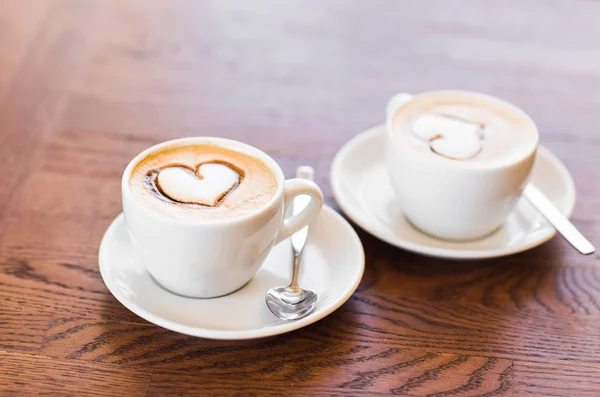 Two cups of coffee with heart pattern — Stock Photo, Image