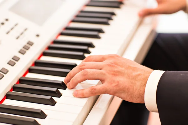 Hands of musician close-up. Pianist playing on electric piano
