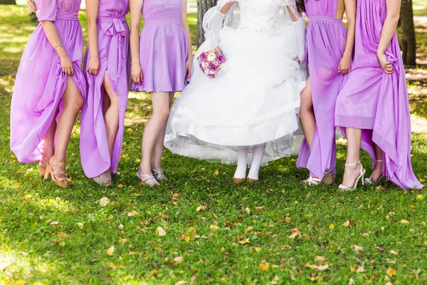 Bruid en bruidsmeisjes pronken met hun schoenen op bruiloft. — Stockfoto