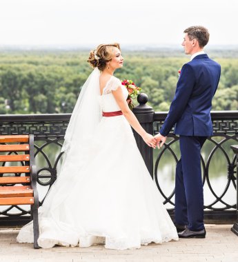 Gelin ve damat dışarıda el ele tutuşuyorlar..