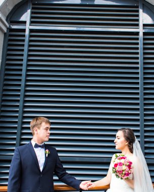 Gelin ve damat dışarıda el ele tutuşuyorlar..