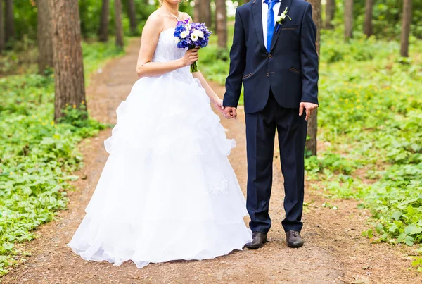 Noiva e noivo de mãos dadas ao ar livre . — Fotografia de Stock