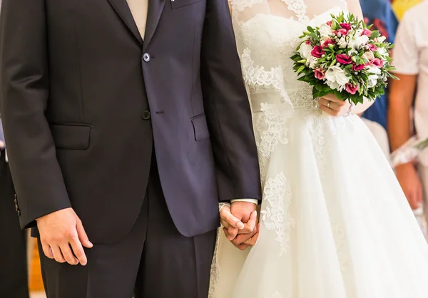 Braut und Bräutigam halten Händchen im Freien. — Stockfoto